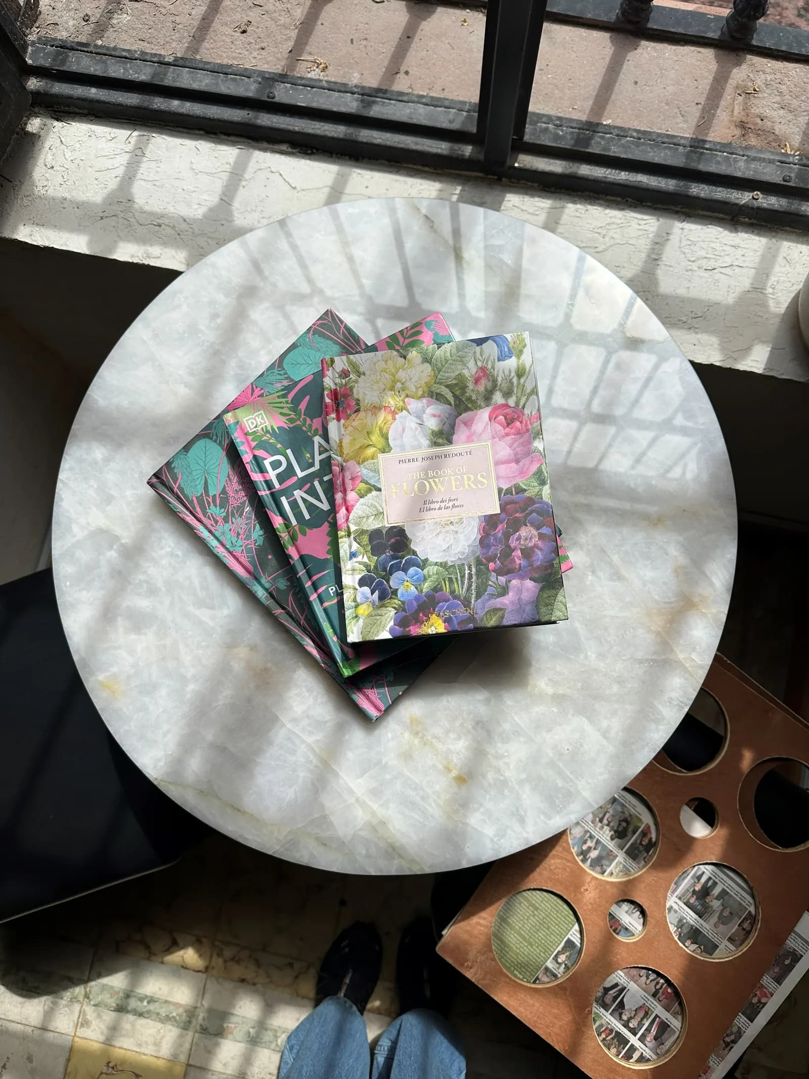 Mesa con libros, materiales y flores prensadas del taller.