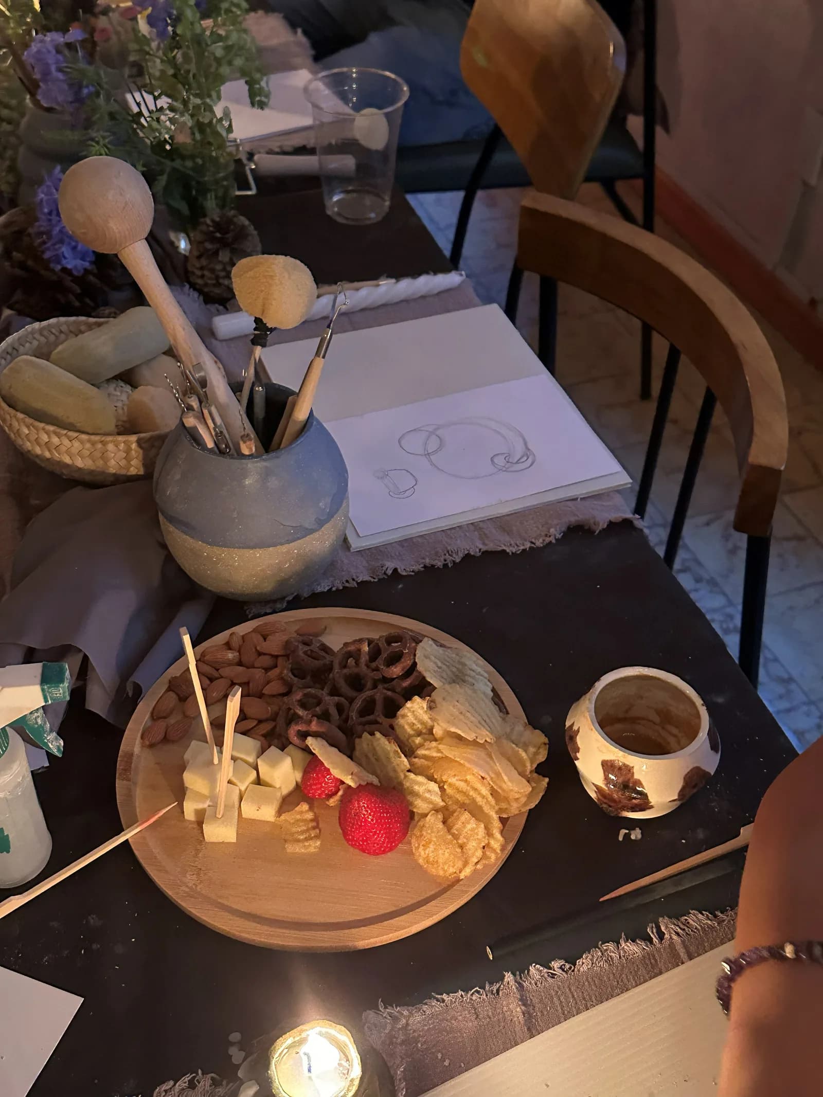 Mesa con bocadillos y velas dispuesta para el taller de cerámica.