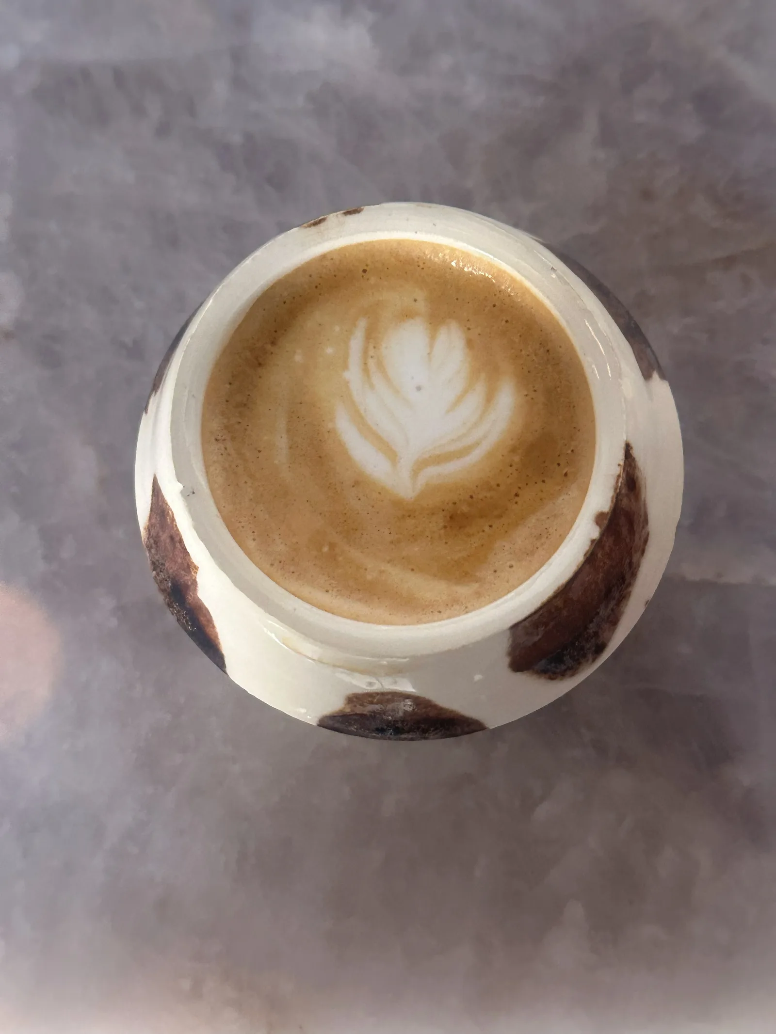Vista cenital de una taza artesanal con arte latte.
