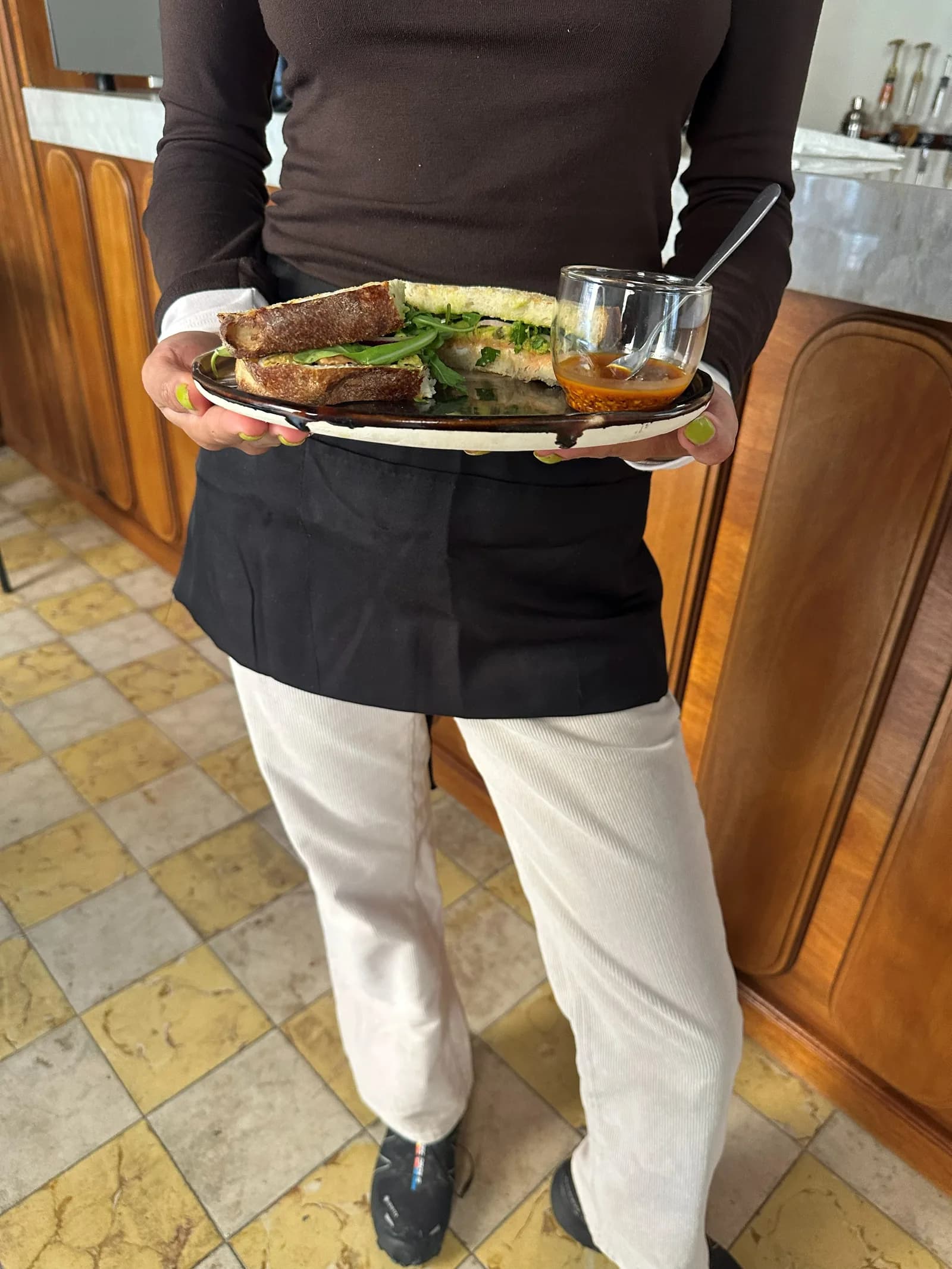 Un mesero lleva una charola con platillos de brunch.