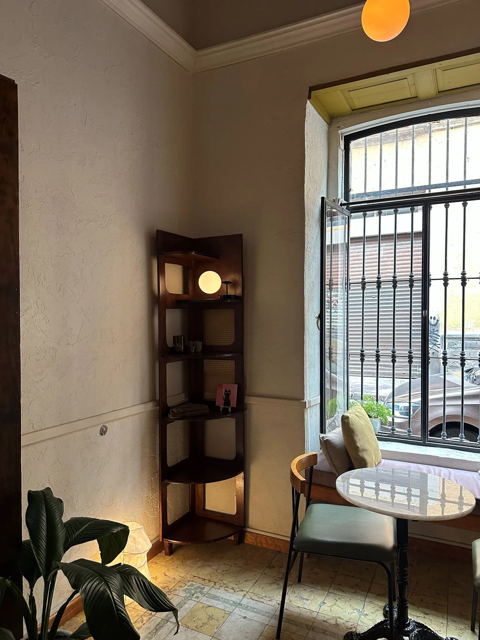 Un rincón del café con ventana y mobiliario de madera.